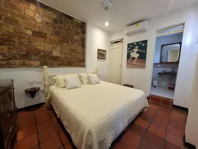 a bedroom with a bed and a brick wall at Hotel Casa de Las Palmas in Cartagena de Indias
