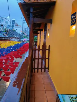 a building with a fence with red and blue umbrellas at Hotel Casa Centenario Getsemaní in Cartagena de Indias
