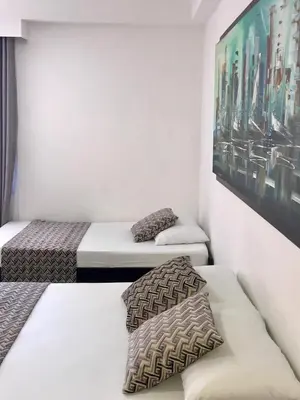 a room with two beds and a painting on the wall at Apartamentos Cartagena Caribe Suite in Cartagena de Indias