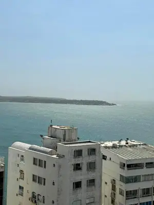 a white building next to the ocean with a body of water at Apartamentos Cartagena Caribe Suite in Cartagena de Indias