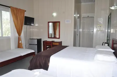 a hotel room with two beds and a shower at Hotel Nitana in Coveñas