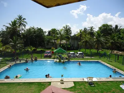 a pool at a resort with people in it at Hotel Nitana in Coveñas