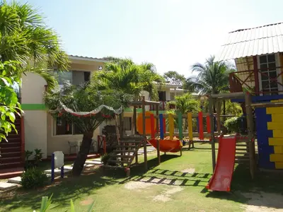a playground with a slide and a swing set at Hotel Nitana in Coveñas
