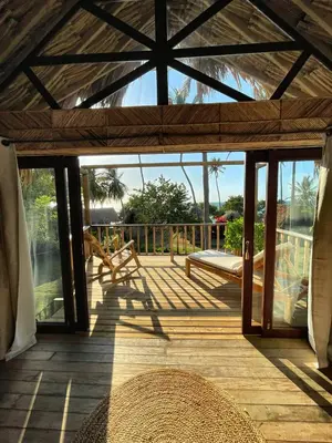 a screened in porch with a view of the ocean at Hotel Isla Mucura in Isla Mucura