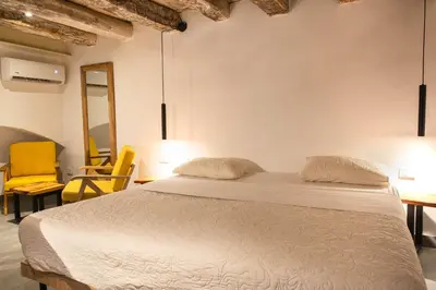 a bedroom with a bed and two yellow chairs at La Passion by Masaya Collection in Cartagena de Indias