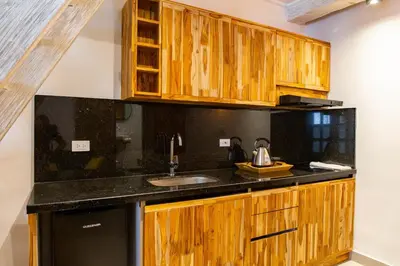 a kitchen with wooden cabinets and a sink at La Passion by Masaya Collection in Cartagena de Indias