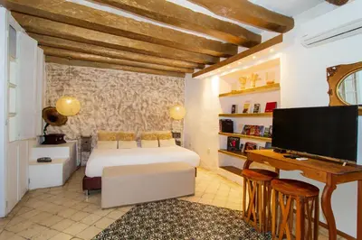 a bedroom with a bed and a flat screen tv at La Passion by Masaya Collection in Cartagena de Indias