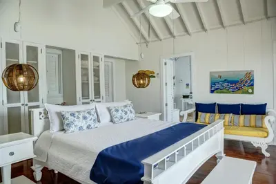 a white bedroom with a bed and a couch at Hotel Agua Azul Beach Resort in Baru