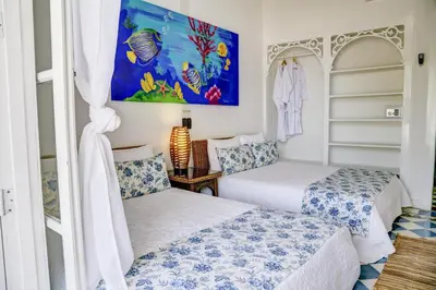 a bedroom with two beds and a painting on the wall at Hotel Agua Azul Beach Resort in Baru
