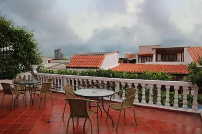 a patio with tables and chairs on a balcony at Hotel Villa Colonial By Akel Hotels in Cartagena de Indias
