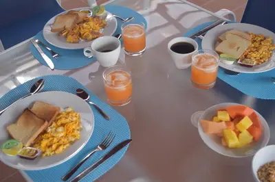 a table with plates of food and glasses of orange juice at Hotel Villa Colonial By Akel Hotels in Cartagena de Indias