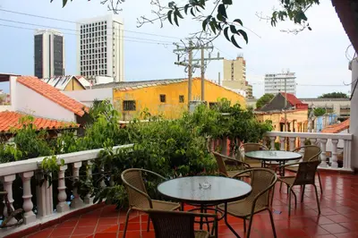 a balcony with tables and chairs and a city skyline at Hotel Villa Colonial By Akel Hotels in Cartagena de Indias