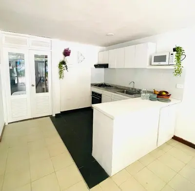 a kitchen with white cabinets and a white counter top at Casa de playa en Bello Horizonte a una cuadra del mar in Santa Marta