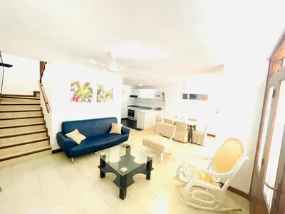 a living room with a blue couch and a table at Casa de playa en Bello Horizonte a una cuadra del mar in Santa Marta