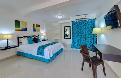 a bedroom with a bed and a desk and a computer at Hotel Dorado Plaza Punta Arena in Tierra Bomba