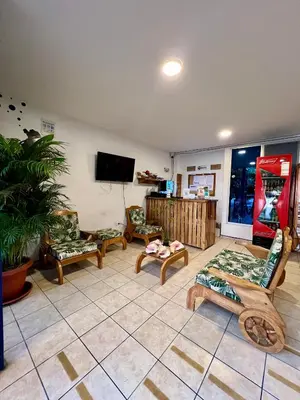 a living room with chairs and a flat screen tv at Hostel Beach House in Rincón