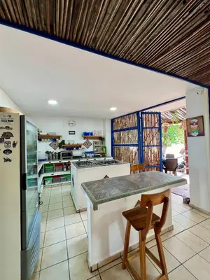 a kitchen with a table and two stools at Hostel Beach House in Rincón