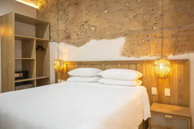 a bedroom with a bed with white sheets and pillows at Hotel Casa La Mantilla by Faranda Boutique in Cartagena de Indias