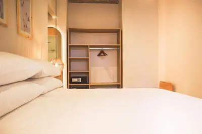 a bedroom with a white bed and a closet at Hotel Casa La Mantilla by Faranda Boutique in Cartagena de Indias