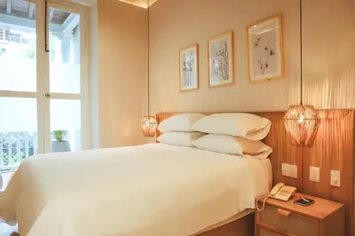 a bedroom with a bed with white sheets and pillows at Hotel Casa La Mantilla by Faranda Boutique in Cartagena de Indias