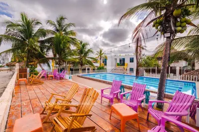 a group of chairs and tables next to a swimming pool at Caribbean Town Tolu in Tolú