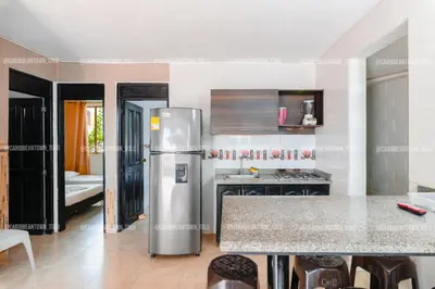 a kitchen with a stainless steel refrigerator in a room at Caribbean Town Tolu in Tolú