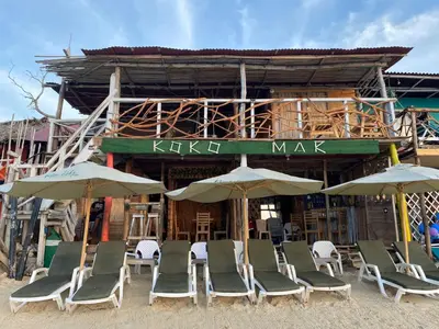a group of chairs and umbrellas in front of a building at Raw KokoMar CasaNativa in Baru