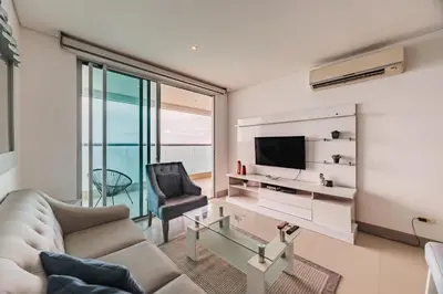 a living room with a couch and a television at Palmetto Beach by MOME in Cartagena de Indias