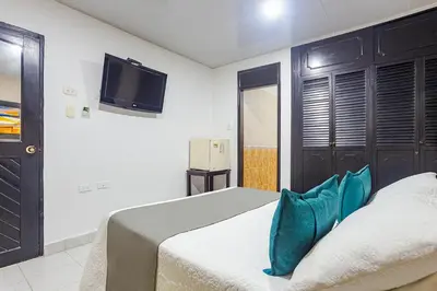 a bedroom with a bed and a tv on the wall at Hotel Ancor in Sincelejo