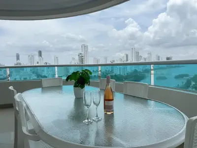 a table with two bottles and glasses on a balcony at Apartamento semi penhouse in Cartagena de Indias