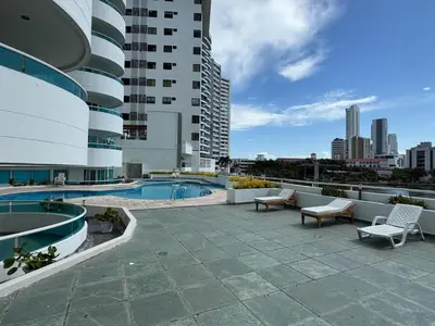 a patio with a pool and chairs and a building at Apartamento semi penhouse in Cartagena de Indias
