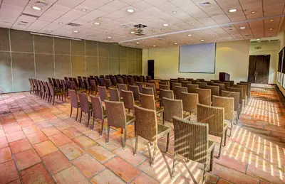 a room with a bunch of chairs and a screen at Estelar Playa Manzanillo - All inclusive in Cartagena de Indias