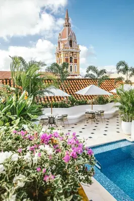 a hotel pool with flowers and a building in the background at Amarla Boutique Hotel Cartagena in Cartagena de Indias