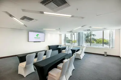 a conference room with white chairs and a screen at Holiday Inn Cartagena Morros by IHG in Cartagena de Indias