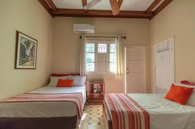 a room with two beds and a window at La casa azul in Cartagena de Indias