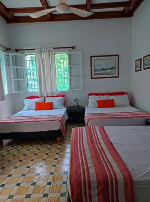 a bedroom with two beds and two windows at La casa azul in Cartagena de Indias