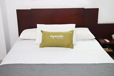 a bed with a yellow pillow on top of it at Ayenda 1801 El Oceano in Cartagena de Indias