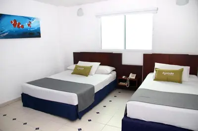 a bedroom with two beds and a window at Ayenda 1801 El Oceano in Cartagena de Indias