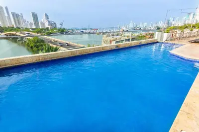 a pool of blue water with a city in the background at GHL Collection Armería Real Hotel in Cartagena de Indias