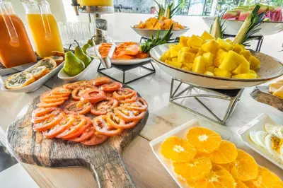 a table with a bunch of food on a table at GHL Collection Armería Real Hotel in Cartagena de Indias