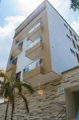 a building with a palm tree in front of it at Hotel Continental Express in Barranquilla