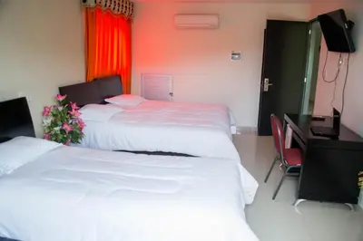 a bedroom with two beds and a desk with a computer at Hotel Continental Express in Barranquilla