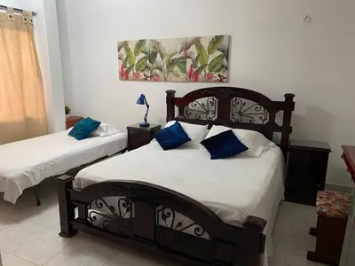 a bedroom with two beds with blue pillows at Habitación I frente a la playa ( Bocagrande ) in Cartagena de Indias
