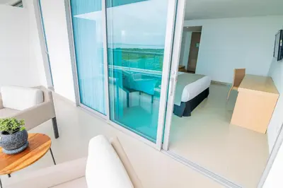 a room with a balcony with a bed and a table at Sonesta Hotel Cartagena in Cartagena de Indias