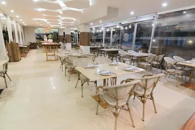 a restaurant with tables and chairs and windows at Sonesta Hotel Cartagena in Cartagena de Indias