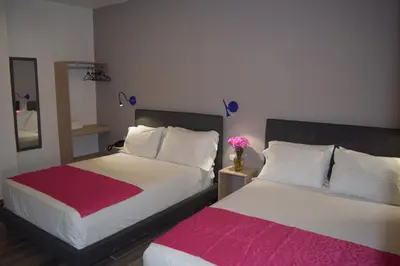 two beds in a room with two at Hotel Yivinaca in Barranquilla