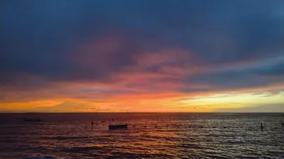 a sunset over the ocean with boats in the water at Vista Linda Cabaña in Playa Blanca