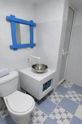 a bathroom with a toilet and a sink at QuillaHost Tropical Apartment in Barranquilla