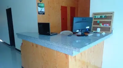 a desk with a computer and a laptop on it at Hotel Troncal Del Caribe in Ciénaga