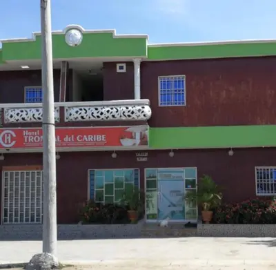 a red and green building with a hotel garage at Hotel Troncal Del Caribe in Ciénaga
